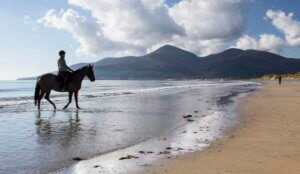 a person on a horse on a beach unique things to do in Ireland