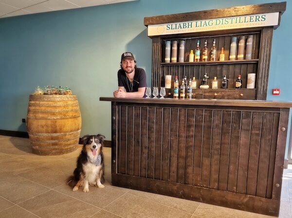 a dog sitting on a floor near a counter Donegal's Ardara Distillery